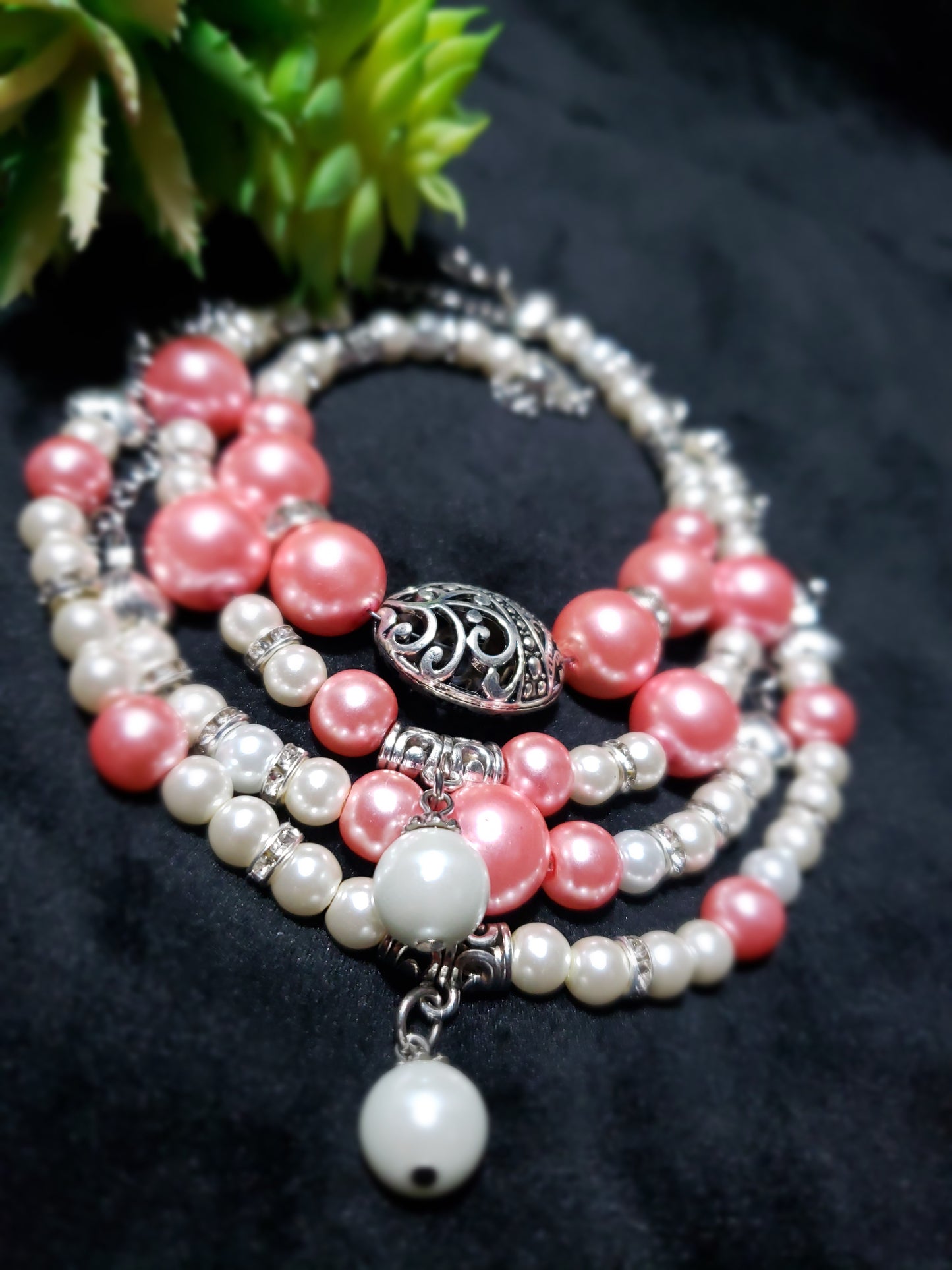 Beaded bracelets with pink and white pearls on a dark background