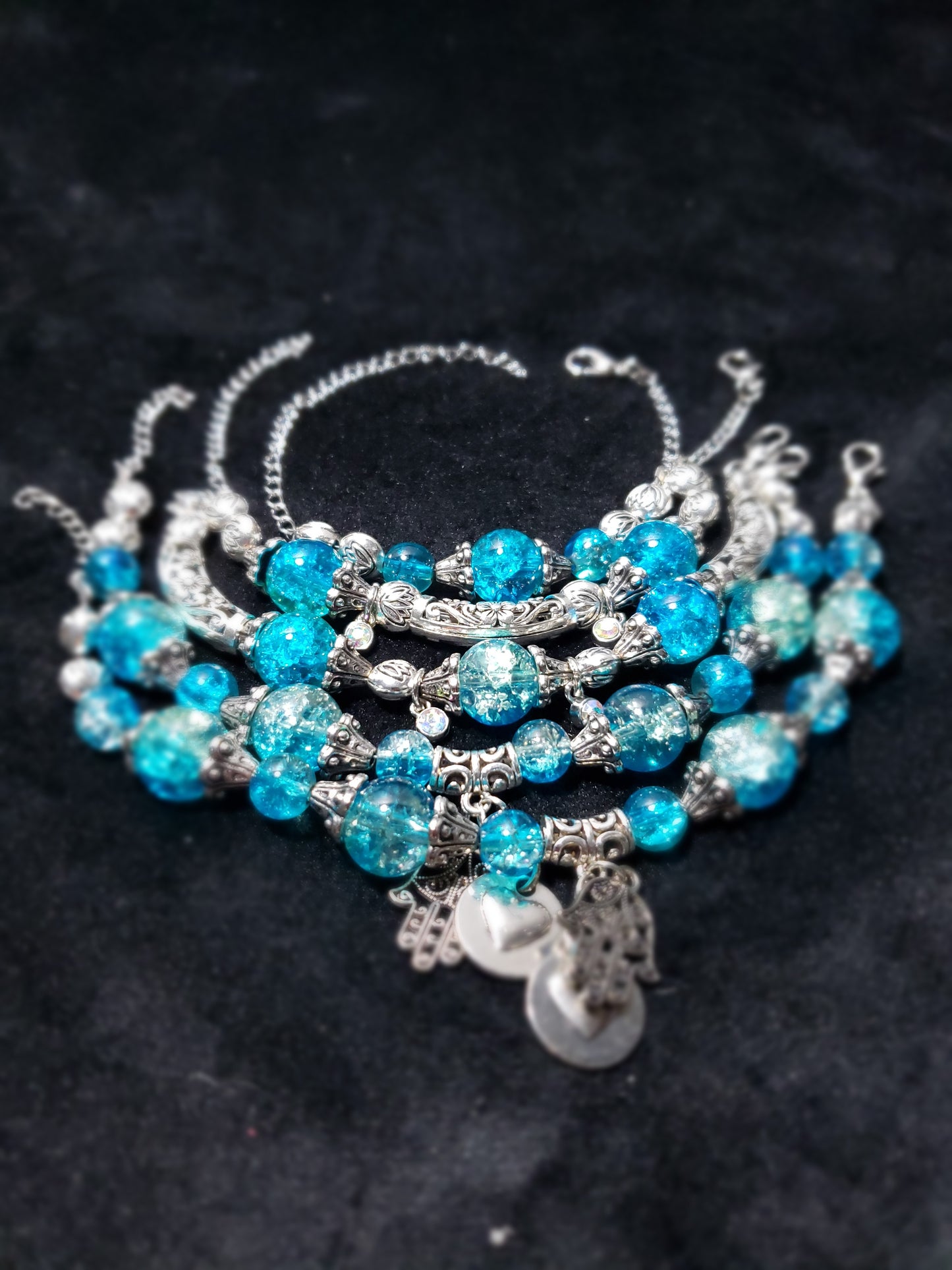 Blue Crackle beaded bracelet with silver accents on a dark background