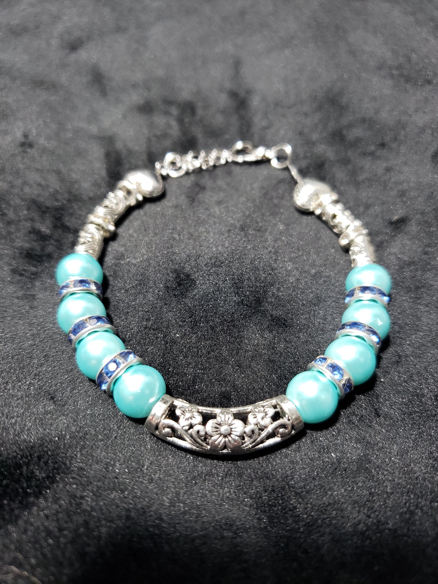Blue beaded bracelet with silver accents on a dark gray background