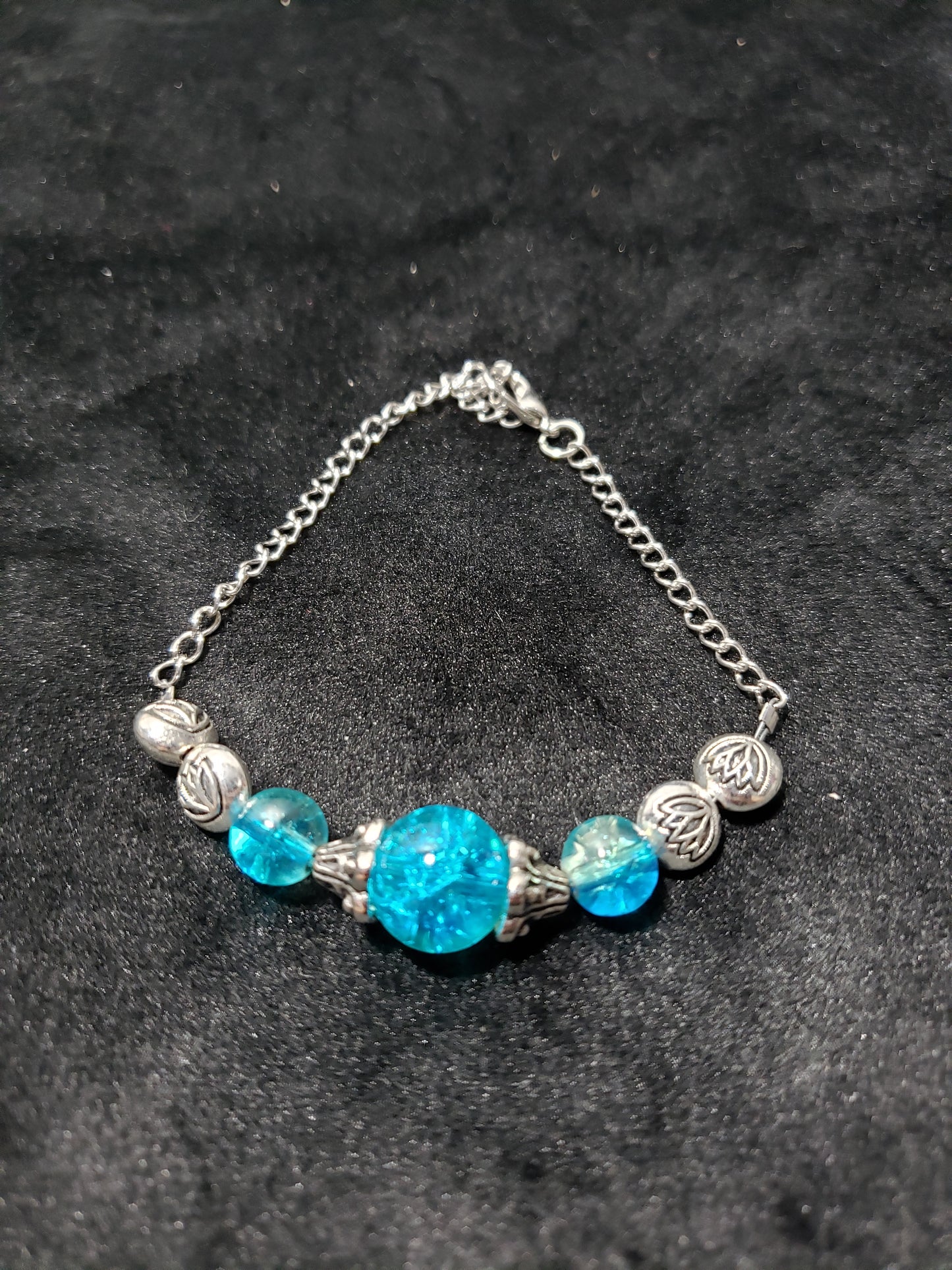 Bracelet with blue beads and silver chain on a dark background