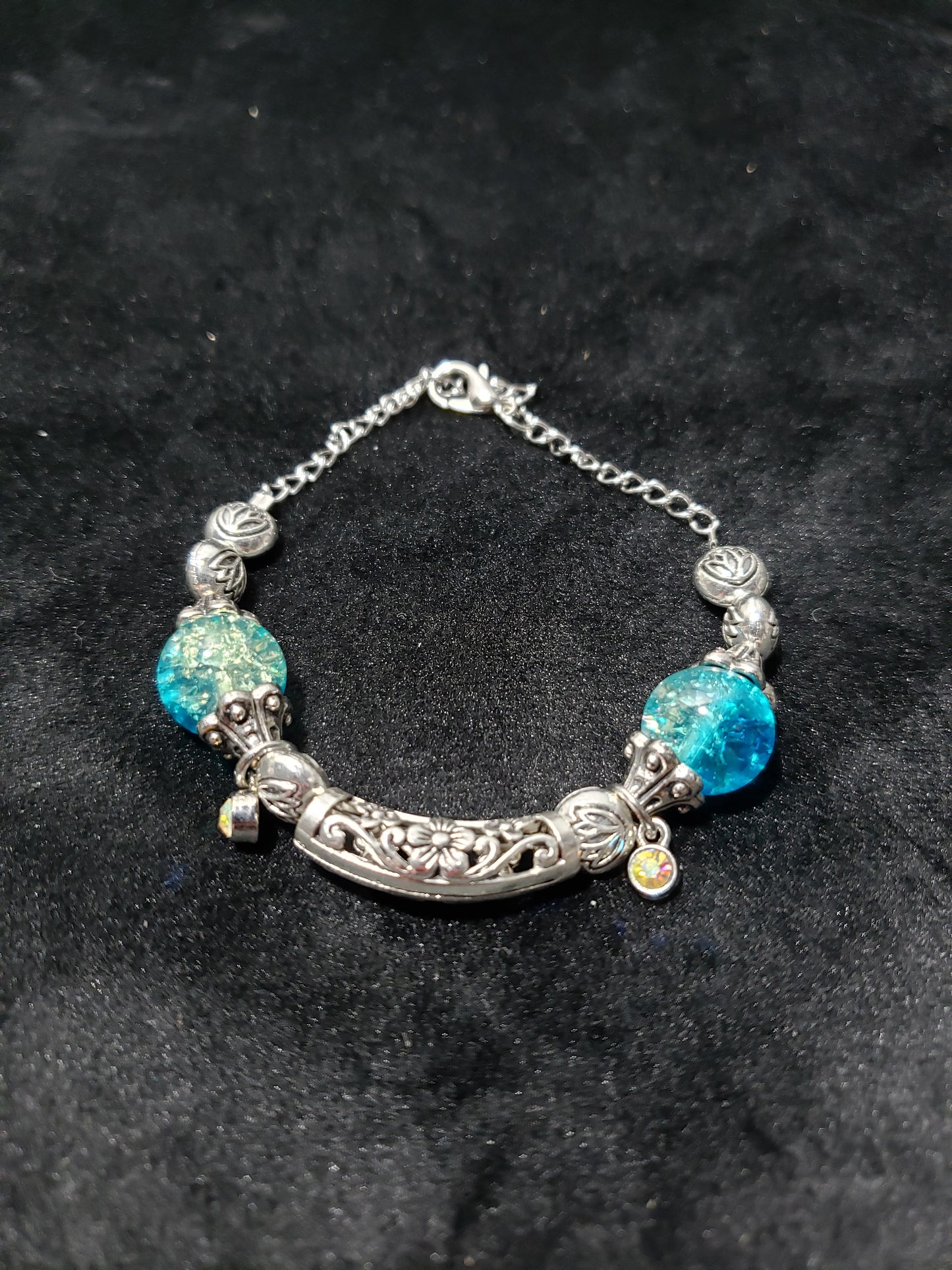 Bracelet with blue crackle beads and silver chain on a black background