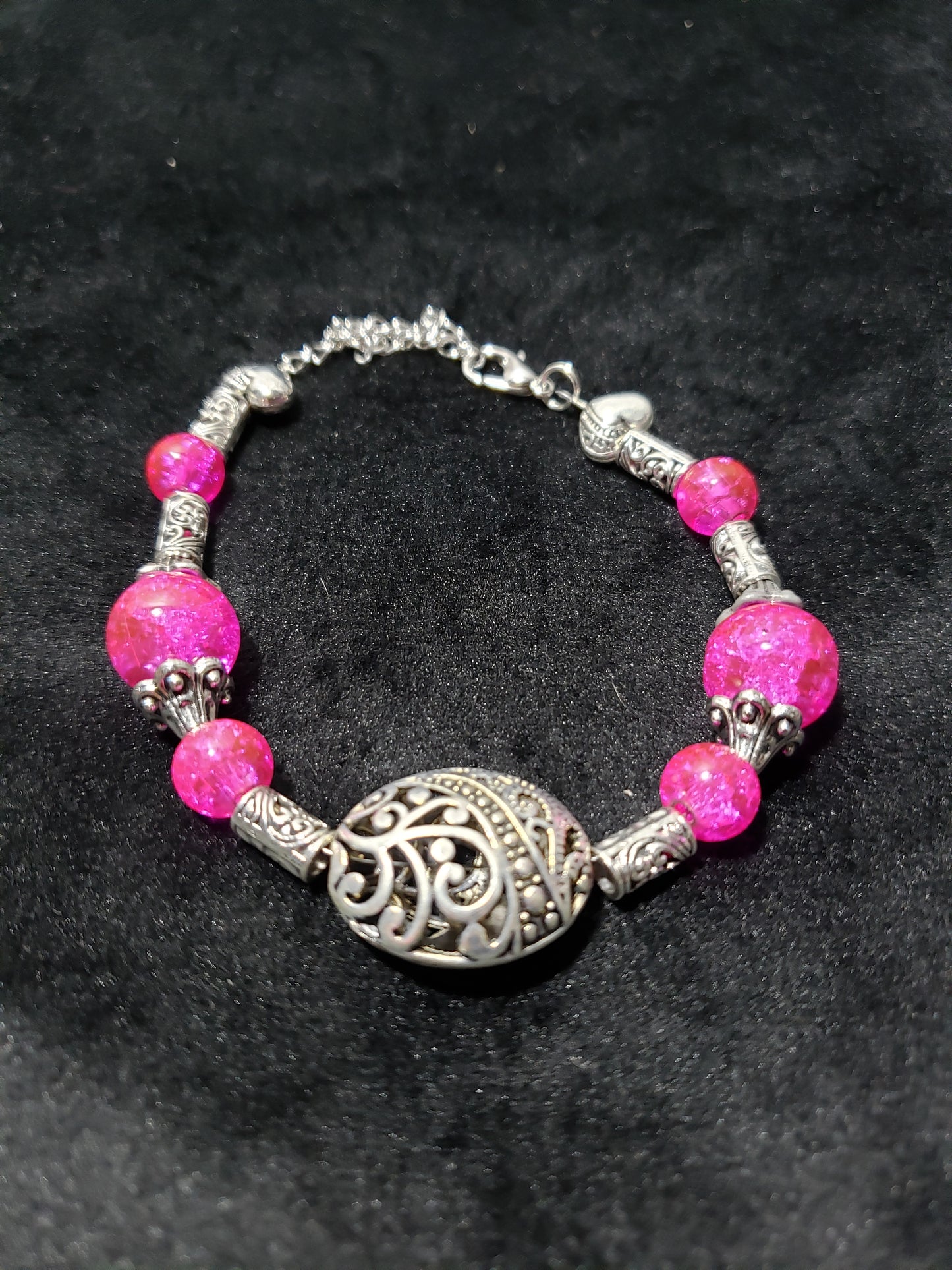Bracelet with pink beads and silver clasp on a black background