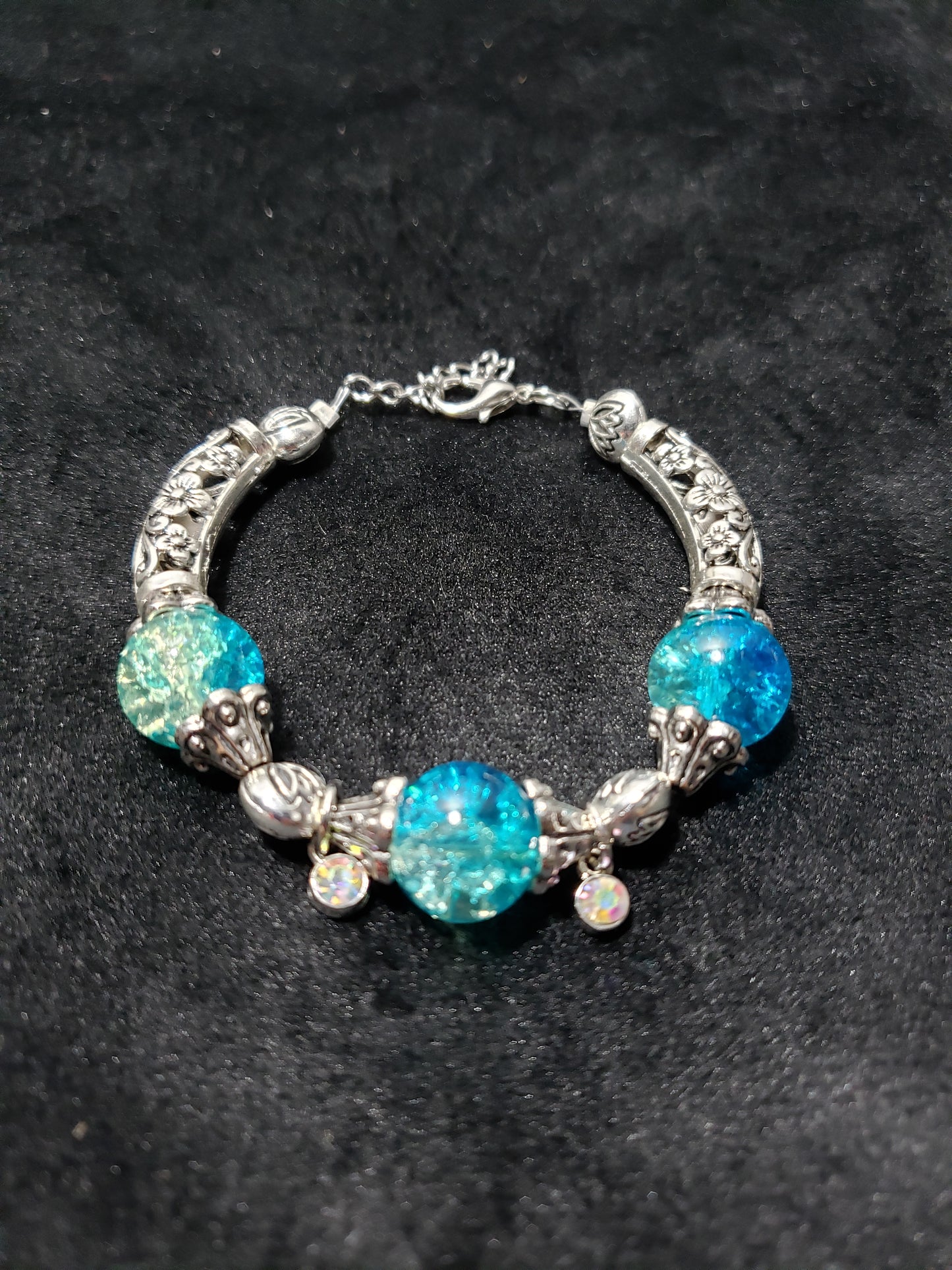 Silver bracelet with blue crackle beads on a black background