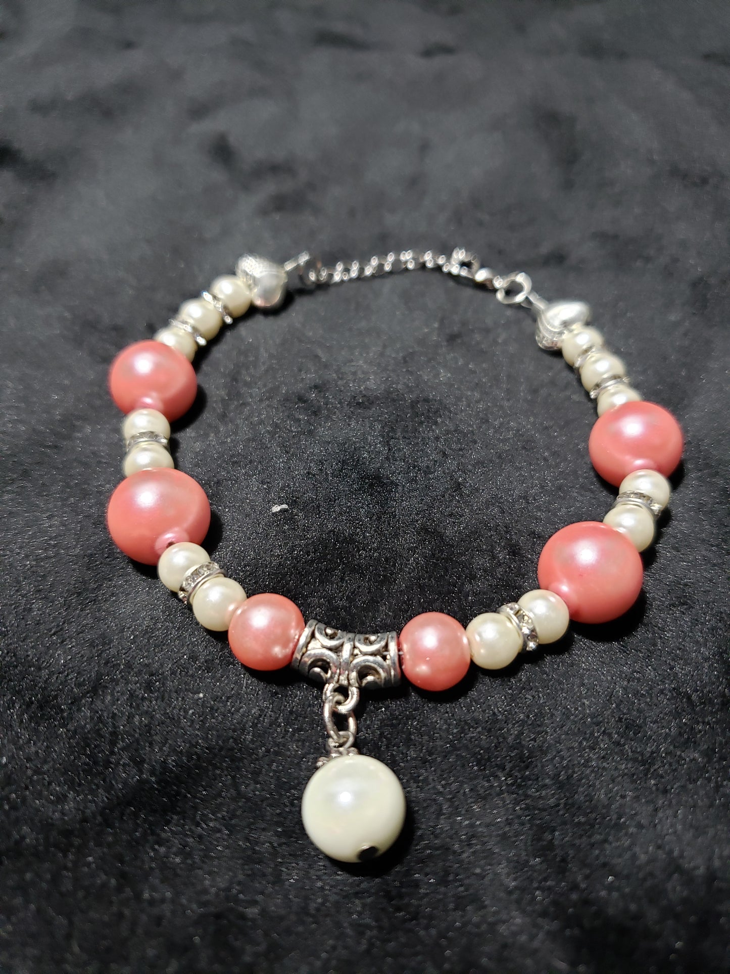 Beaded bracelet with pink and white beads on a dark textured background
