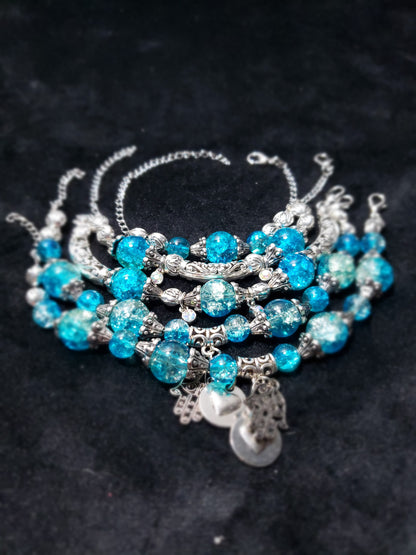 Blue Crackle beaded bracelet with silver accents on a dark background