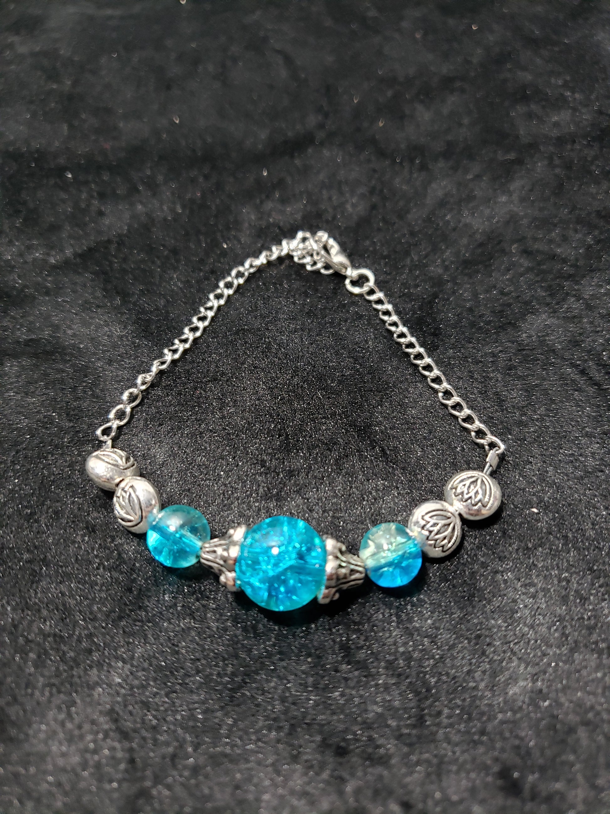 Bracelet with blue beads and silver chain on a dark background