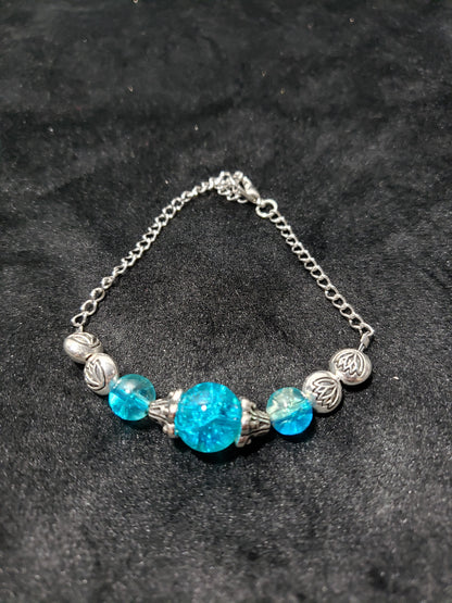 Bracelet with blue beads and silver chain on a dark background