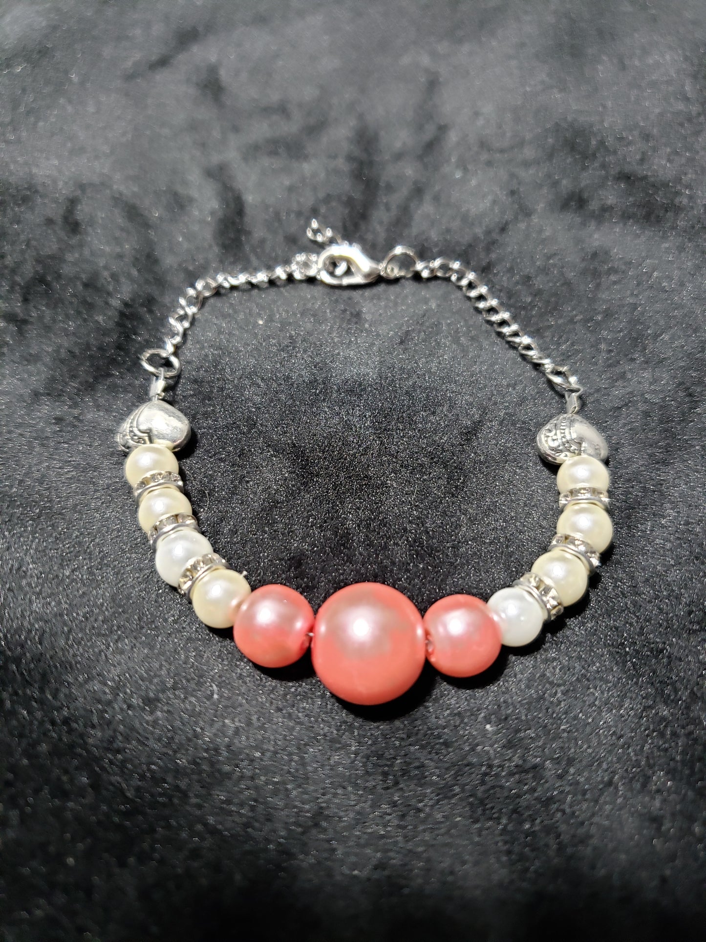 Bracelet with pink and white beads on a dark bsckground
