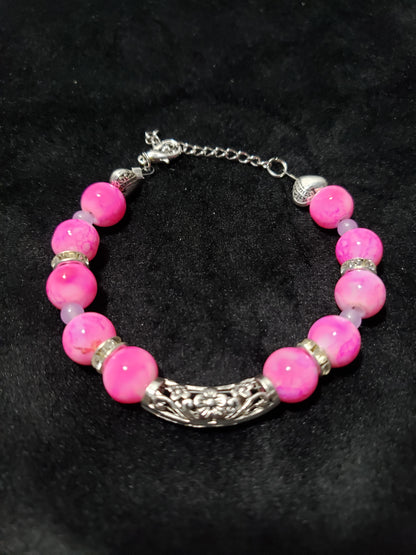 Bracelet with pink marble beads and silver accents on a black background
