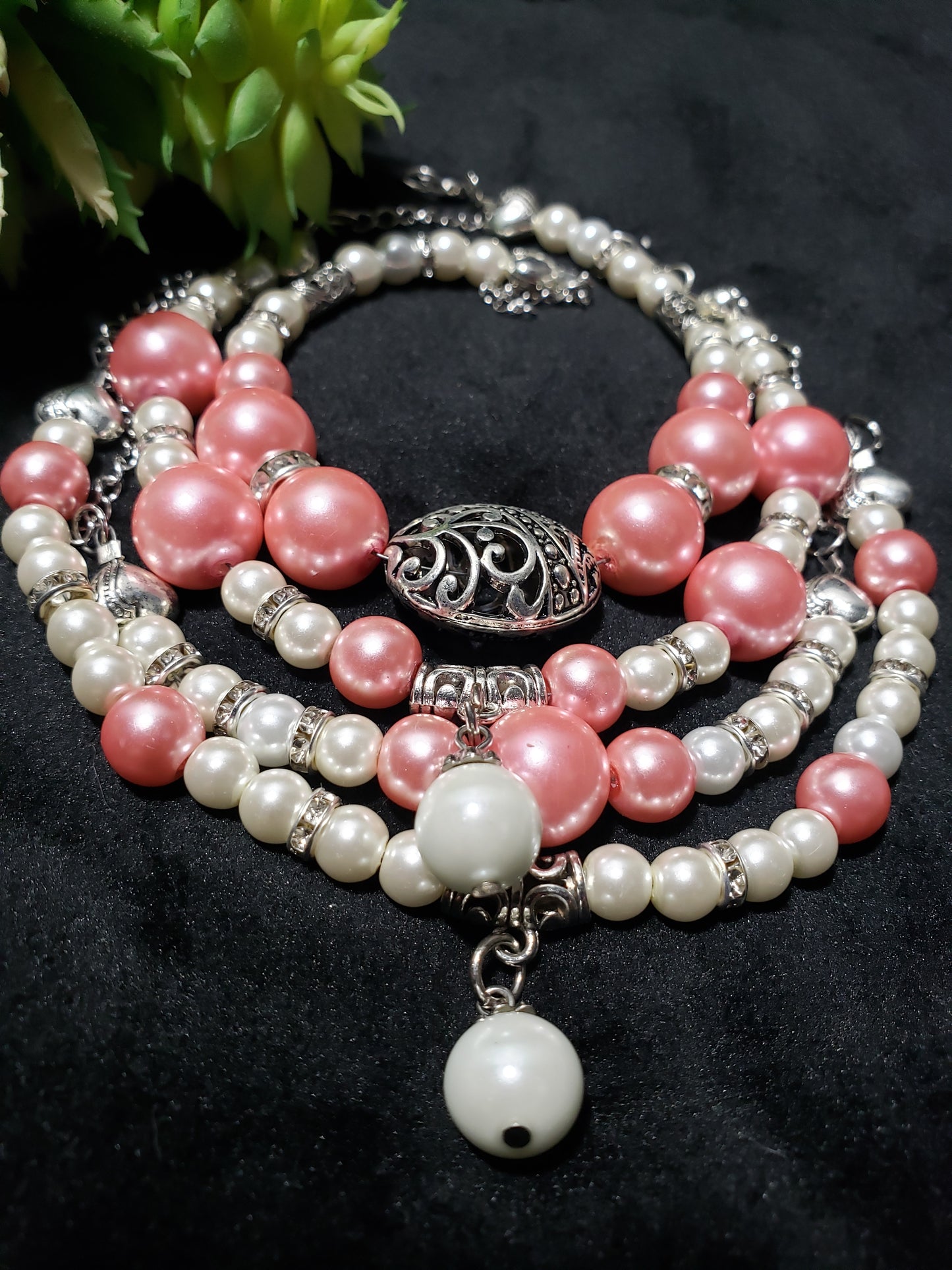 Stack of pink and white beaded bracelets on a dark background