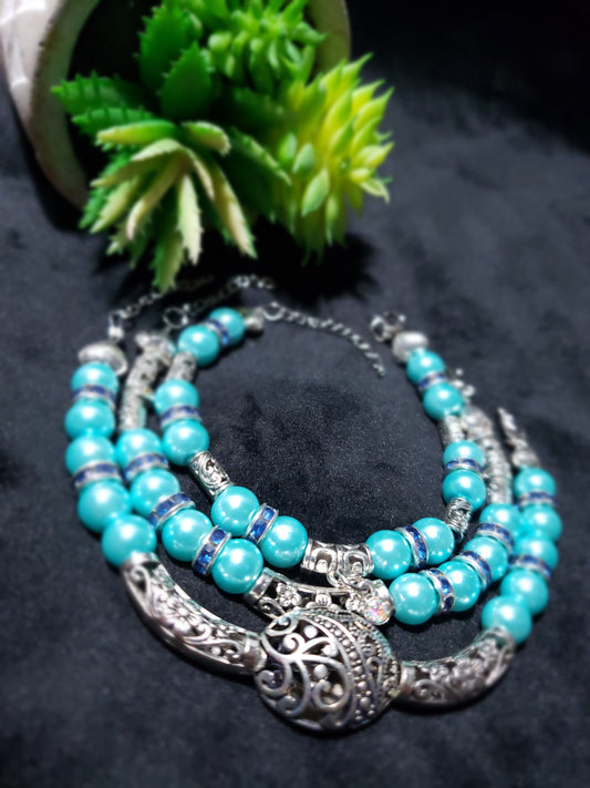 Turquoise beaded bracelet with silver accents on a dark background